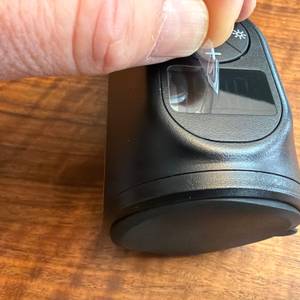 Eine Hand zieht eine Folie vom Display des Osram TyreInflate 2000