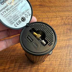 Eine Hand öffnet den Deckel von einem Fach mit Adaptern