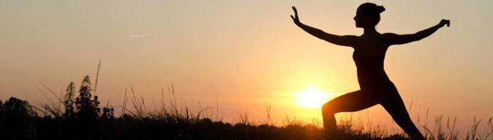 Frau macht Fitnessübungen bei Sonnenuntergang