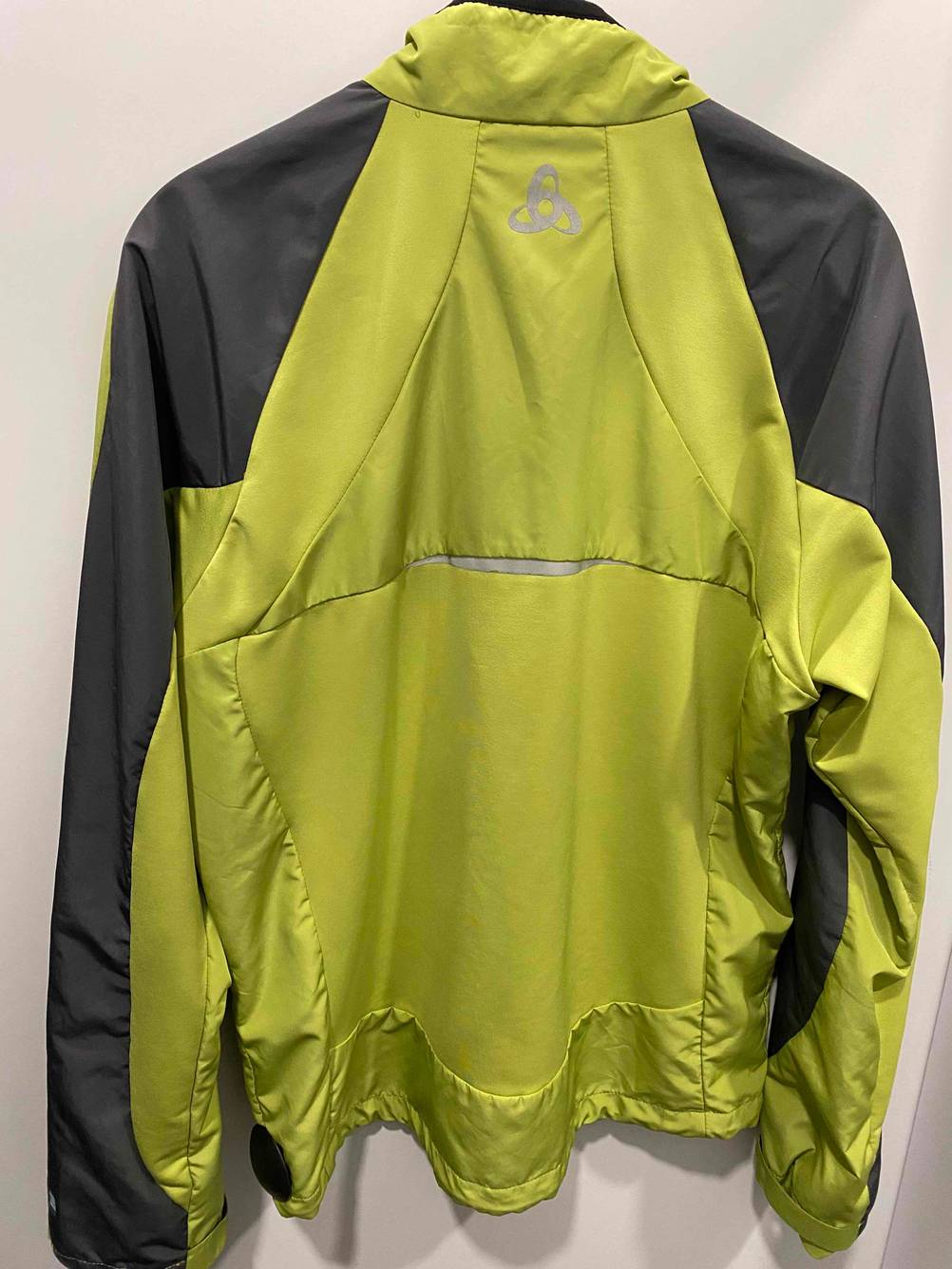 Rückseite einer getesteten Herren-Outdoor-Jacke auf einem Bügel vor einer hellen Wand.
