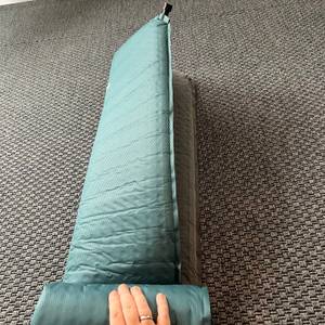Eine Hand rollt die Outdoorer Trek Bed 2 ab