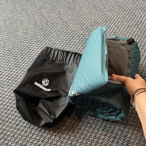 Eine Hand hält die Outdoorer Trek Bed 2 neben ihrer Schutzhülle