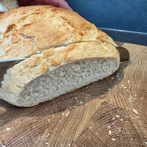 Mit einem Messer wird Weißbrot aus dem Overmont-Feuertopf geschnitten