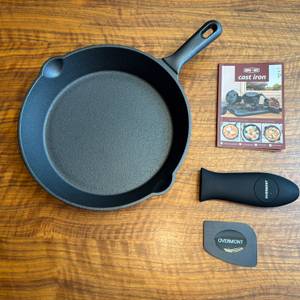 Der Lieferumfang der Overmont-Gusseisenpfanne liegt auf einem Holztisch