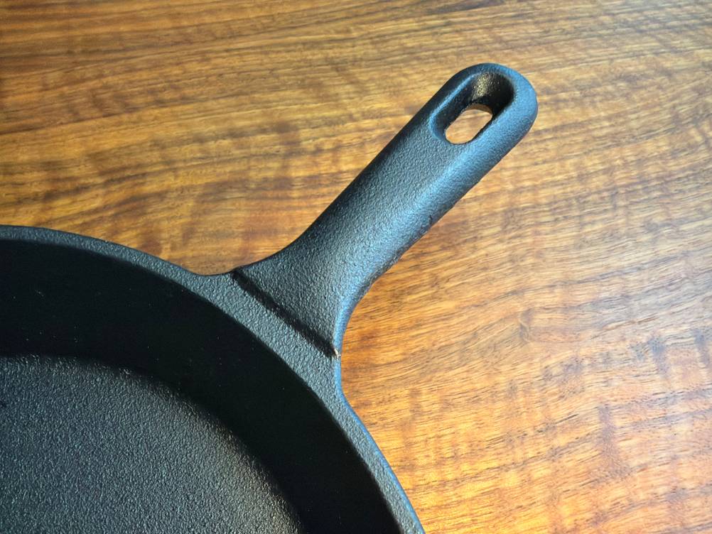 Der Griff der Overmont-Gusseisenpfanne ohne Silikonschutz