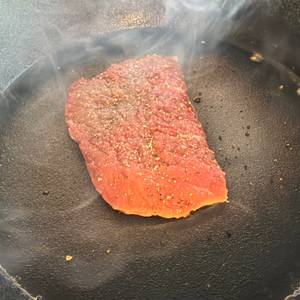 Ein rohes Steak wird in der Overmont-Gusseisenpfanne gebraten