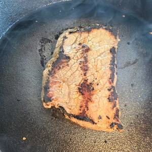 Ein Steak wird in der Overmont-Gusseisenpfanne gebraten