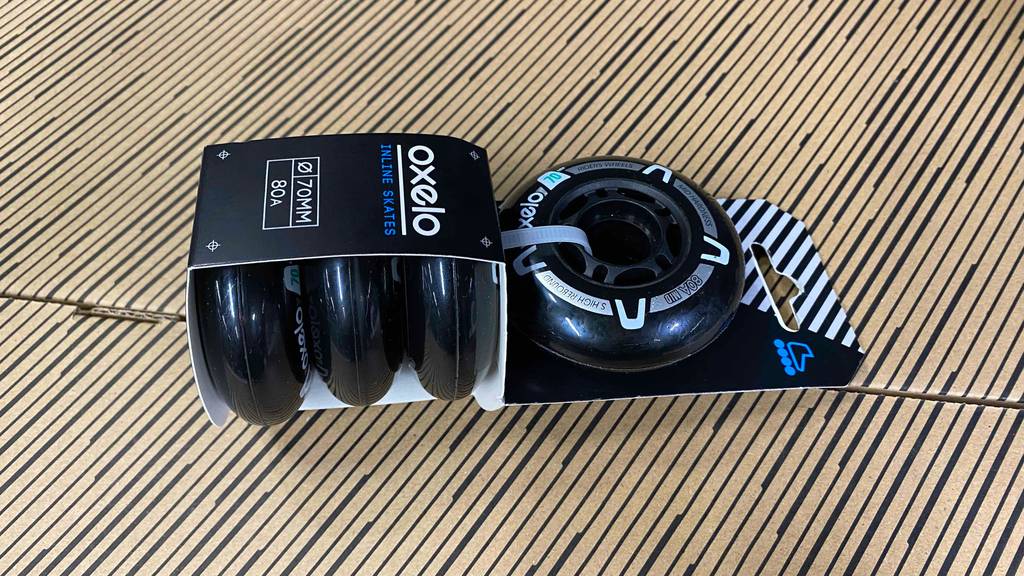 Inliner-Rollen im Test: Ein Viererset in Originalverpackung liegt von der Seite betrachtet auf einer Kartonfläche.