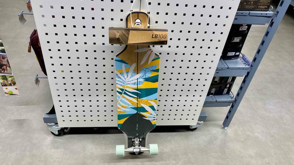 Getestetes Mini-Longboard lehnt am Regal.