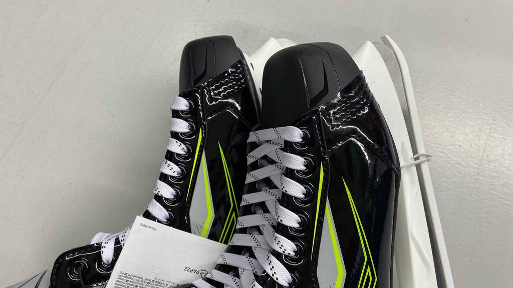 Getestete Oxelo-Schlittschuhe für Herren haben eine schwarze Farbe und neongelbe Details.