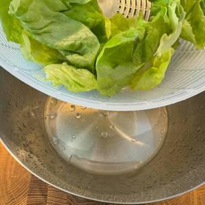 Restwasser in der Schale und frischer, abgetropfter Salat