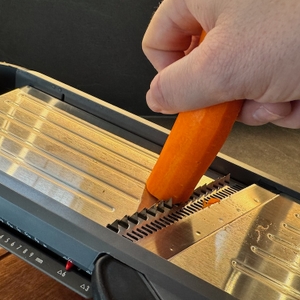 Karotte in der Hand, wird im Oxo-Gemüsehobel geschnitten