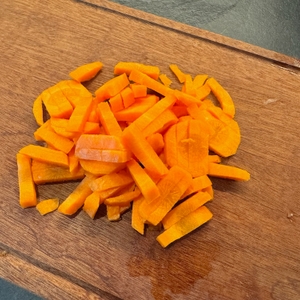 Geschnittene Karottenstücke auf Holzbrett nach dem Schneiden mit dem Oxo-Gemüsehobel.