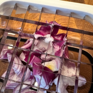 Geschnittene Zwiebeln hängen in den Klingen des Oxo-Good-Grips-Gemüsehacker