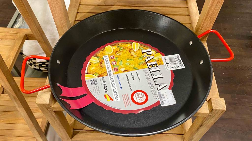 Auf einer Holzoberfläche befindet sich eine getestete Paella-Pfanne.