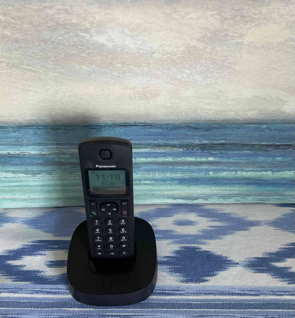 Das schwarze Panasonic-Telefon mit Basis auf blau-weiß-meliertem Stoff ist ein echter Hingucker.