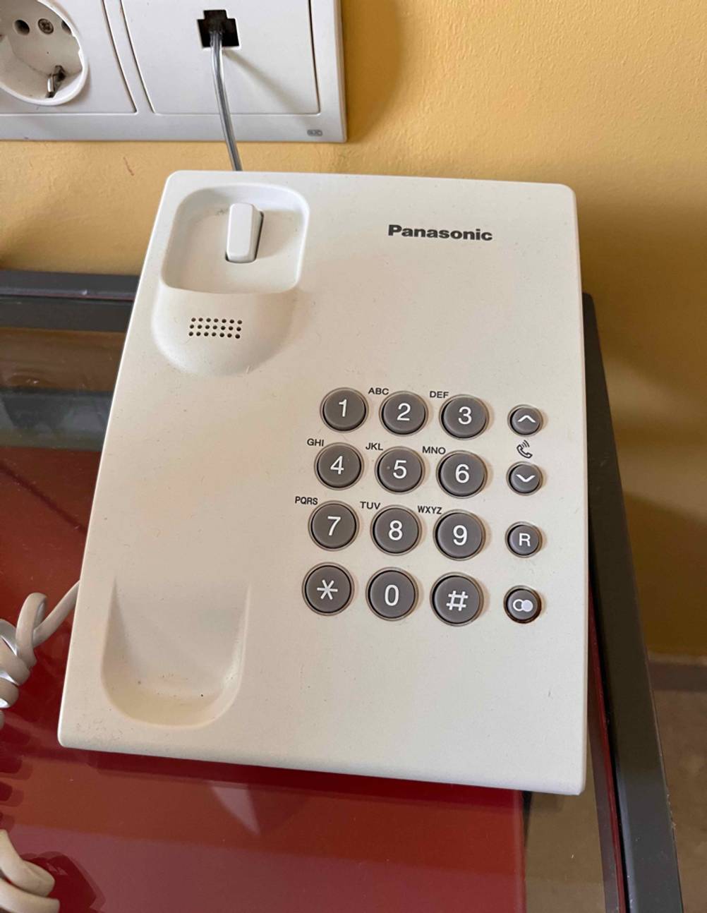 Schnurlostelefone im Test: ein weißes Modell der Marke Panasonic steht vor einer Telefonanschlussbuchse.