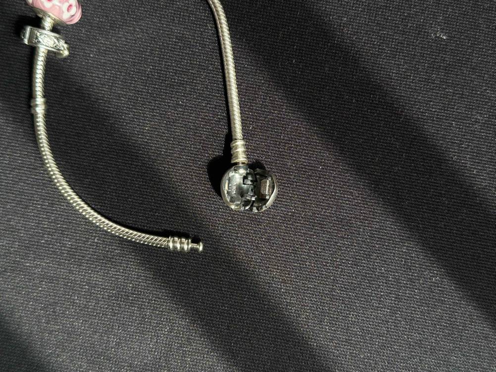 Pandora-Armband im Test: Nahaufnahme des geöffneten Verschlusses auf einer dunklen Fläche.