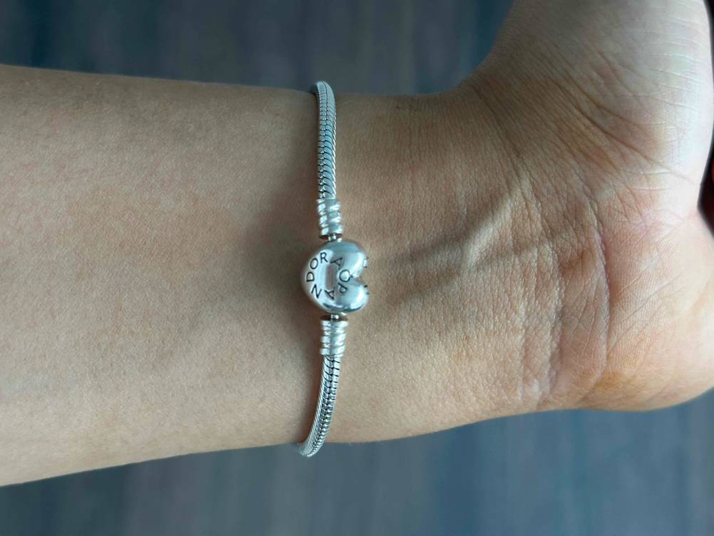 Pandora-Armband-Test: Nahaufnahme des Verschlusses mit Logo an einem Handgelenk.