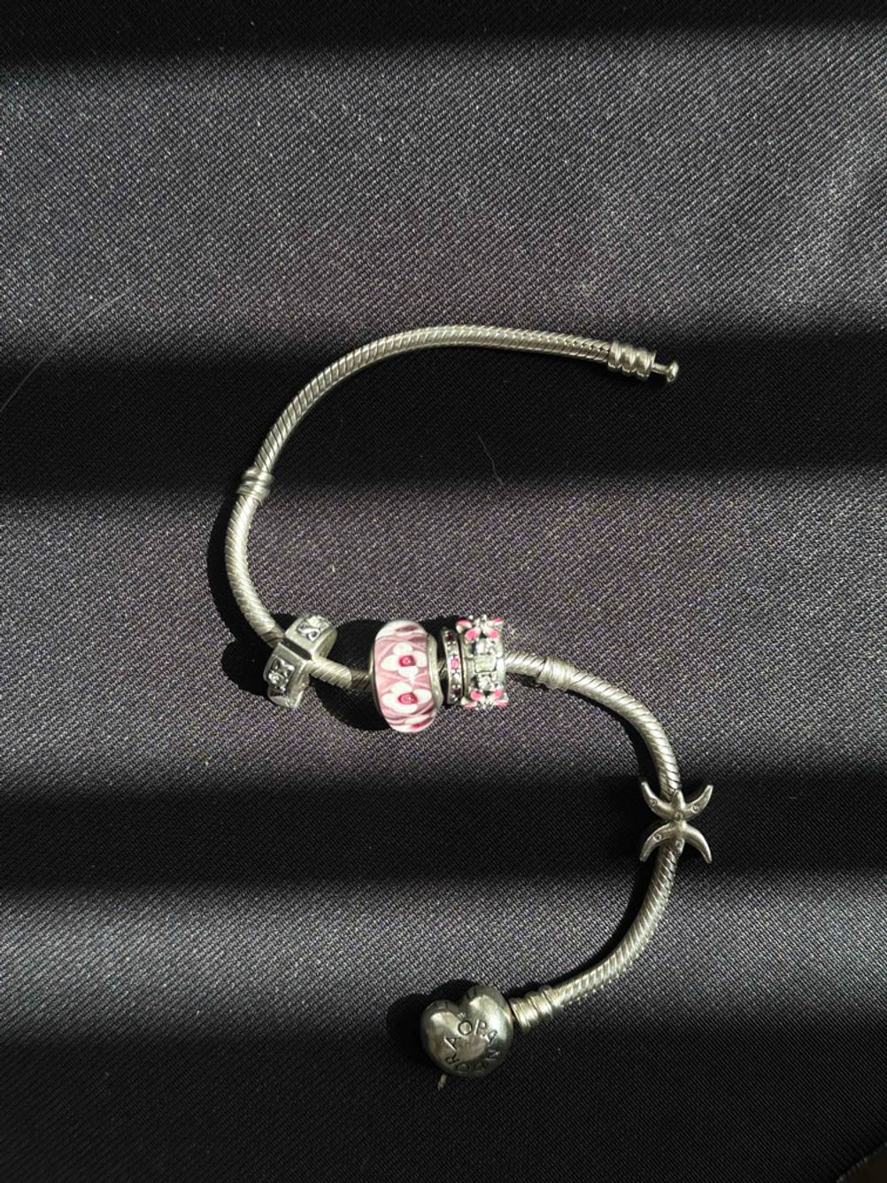 Ein Pandora-Armband im Test in einer S-Kurve ausgelegt auf einem dunklen Untergrund.