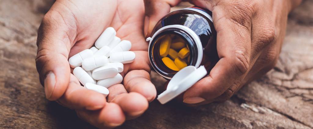 Papain-Test: Eine Person hält Papain-Tabletten und eine Dose in der Hand.