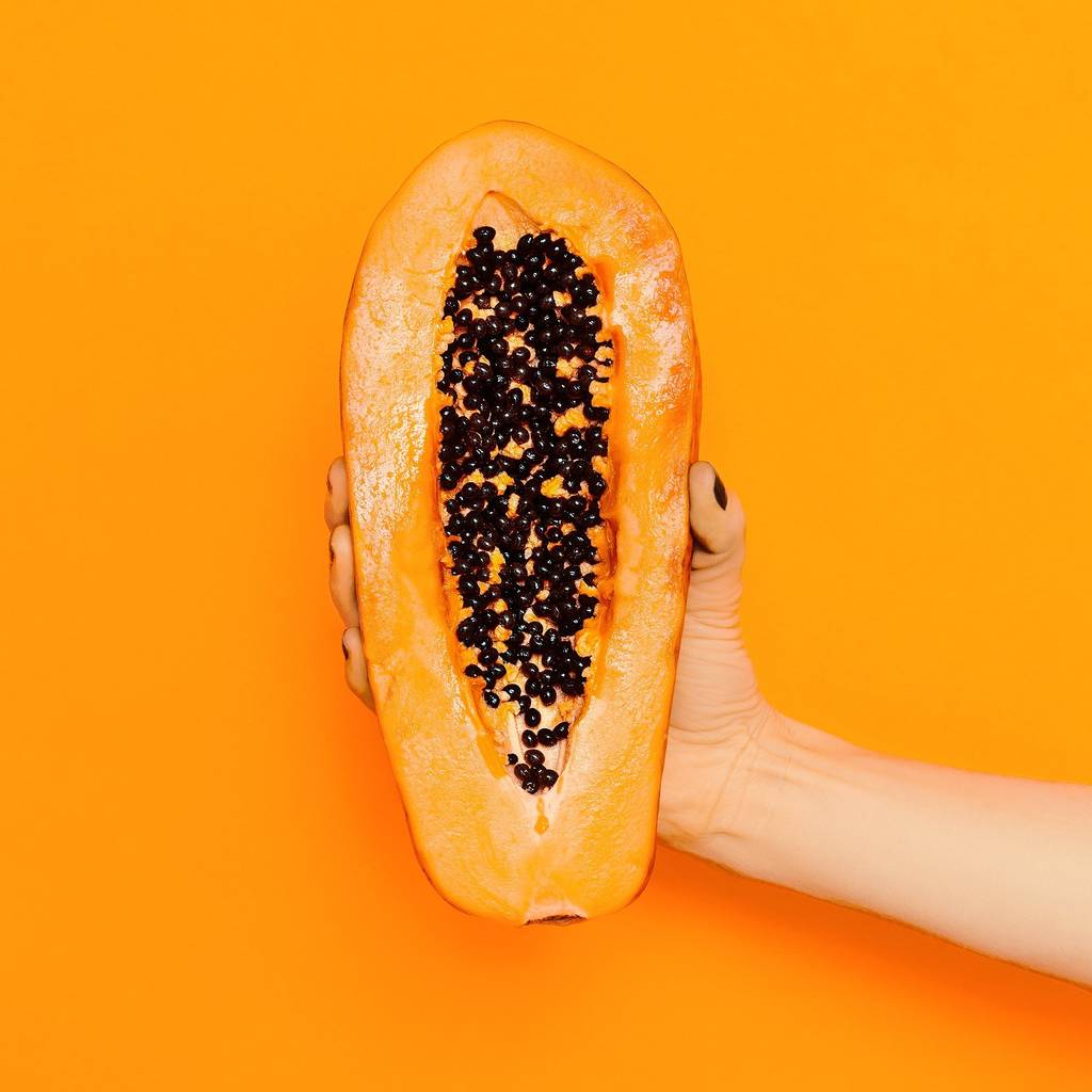 Papain-Test: Eine Frau hält eine aufgeschnittene Papaya in der Hand. 