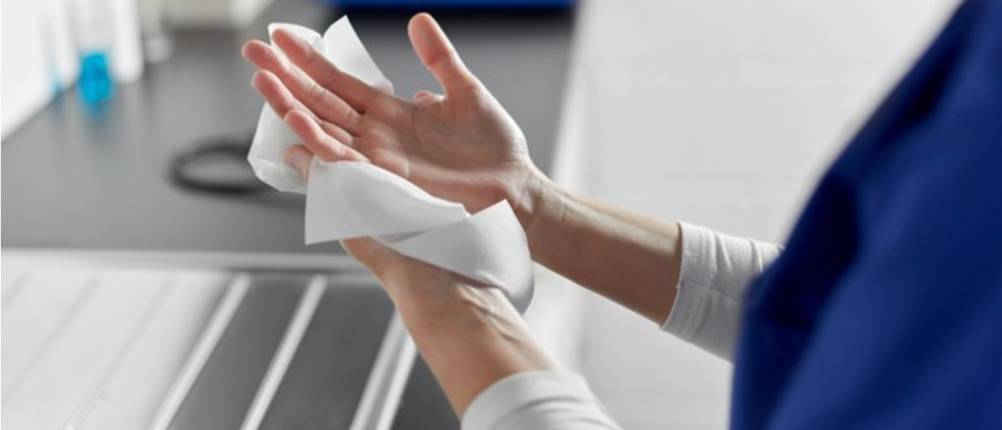 Papierhandtücher-Test: Eine Frau reibt sich die Hände in weißen Papierhandtüchern.