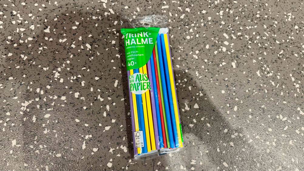 Auf einem Boden liegt eine Packung der getesteten Papierstrohhalme.