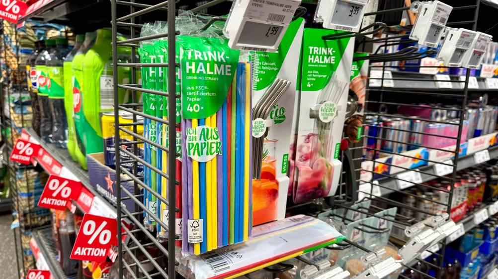 Mehrer Packungen der getesteten Papierstrohhalme hängen in einem Verkaufsregal neben anderen Produkten.