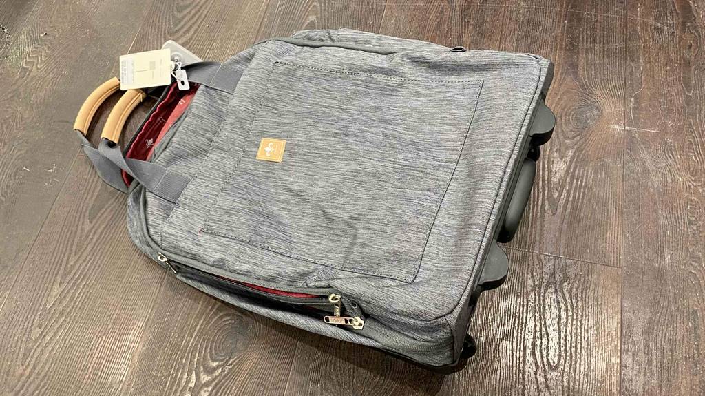 Im Test: Ein Rucksack-Trolley liegt auf einem dunklen Holzboden.