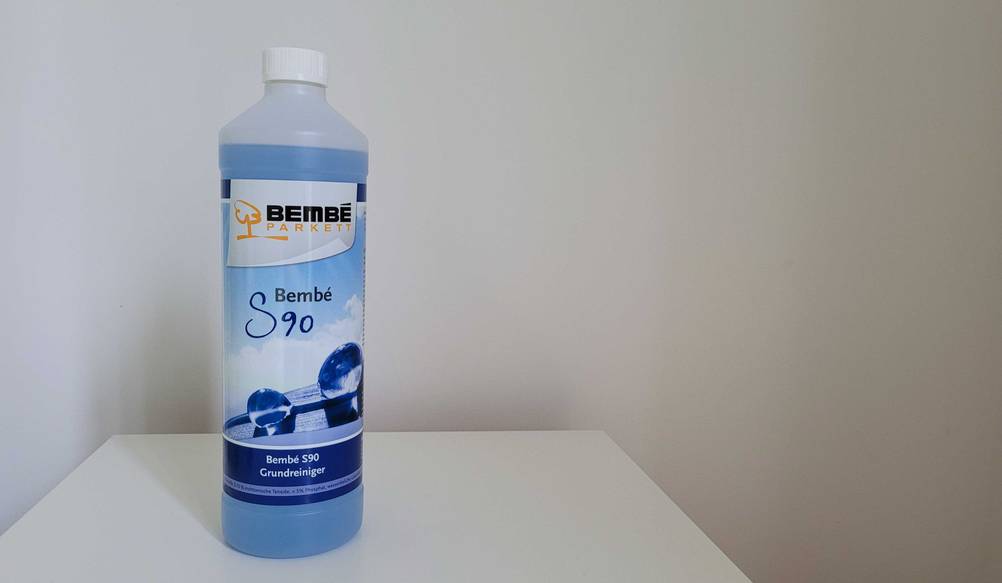 Eine Flasche Parkettreiniger von vorne auf einer hellen Fläche.