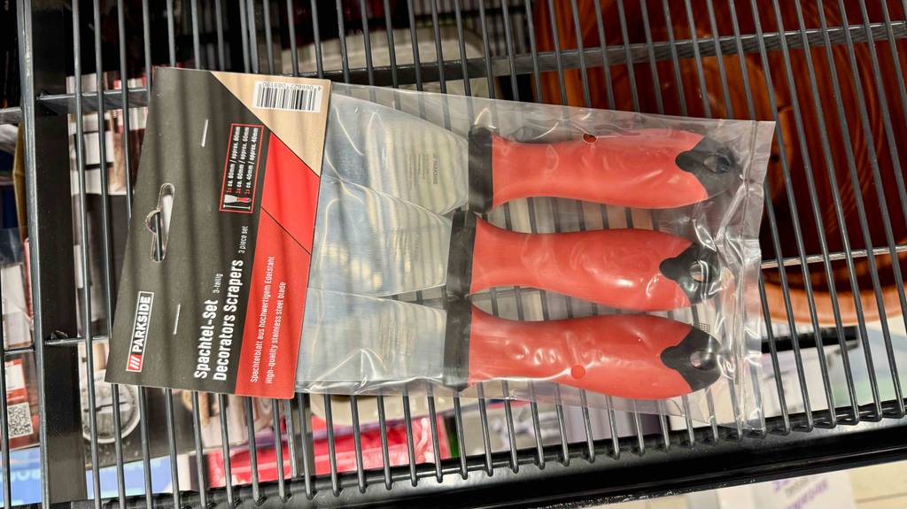 Getestete Spachtel mit orangem Griffen befinden sich im 3-er-Set auf einem Verkaufsregal.