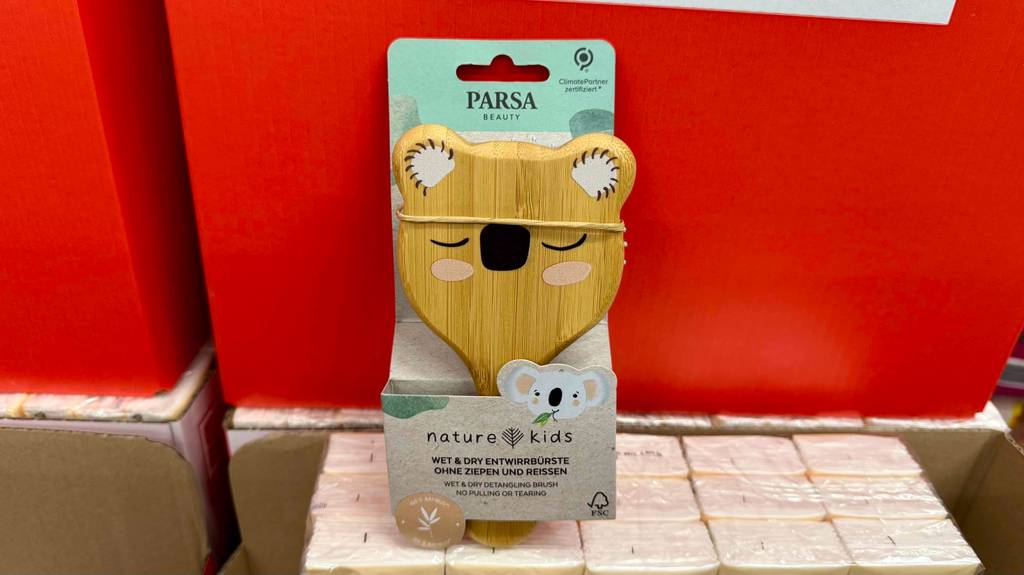 Im Test: Eine Babybürste mit Entwirrborsten steht inklusive Verpackung auf Papiertaschentüchern.