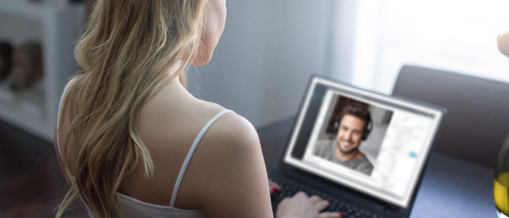 Partnersuche im Test: Eine blonde Frau spricht per Videochat mit einem jungen Mann.