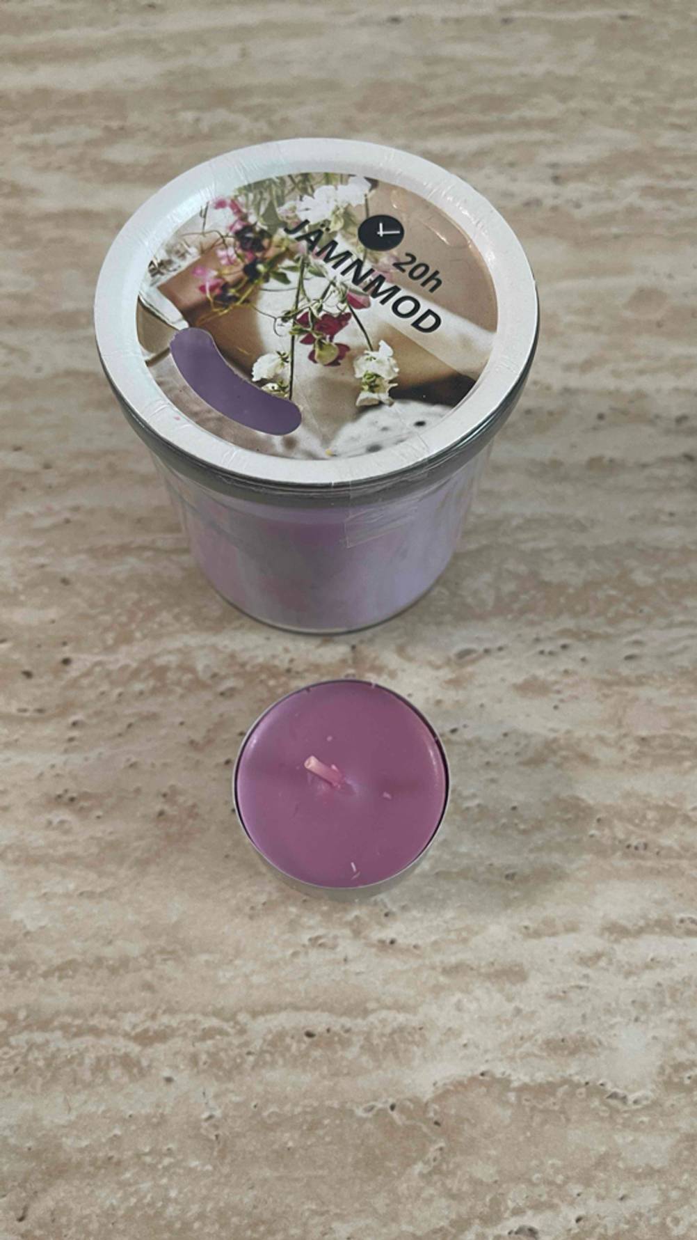 Eine getestete Partylite-Kerze steht vor einer Duftkerze im Glas.