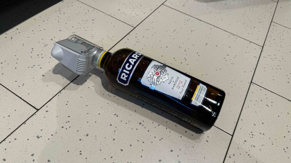 Eine Flasche des Pastis im Test liegt auf einem Steinboden.