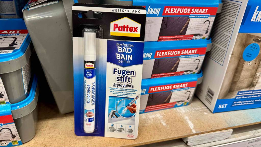 Ein Blister mit einem Fugenstift steht zum testen vor Baumaterial.