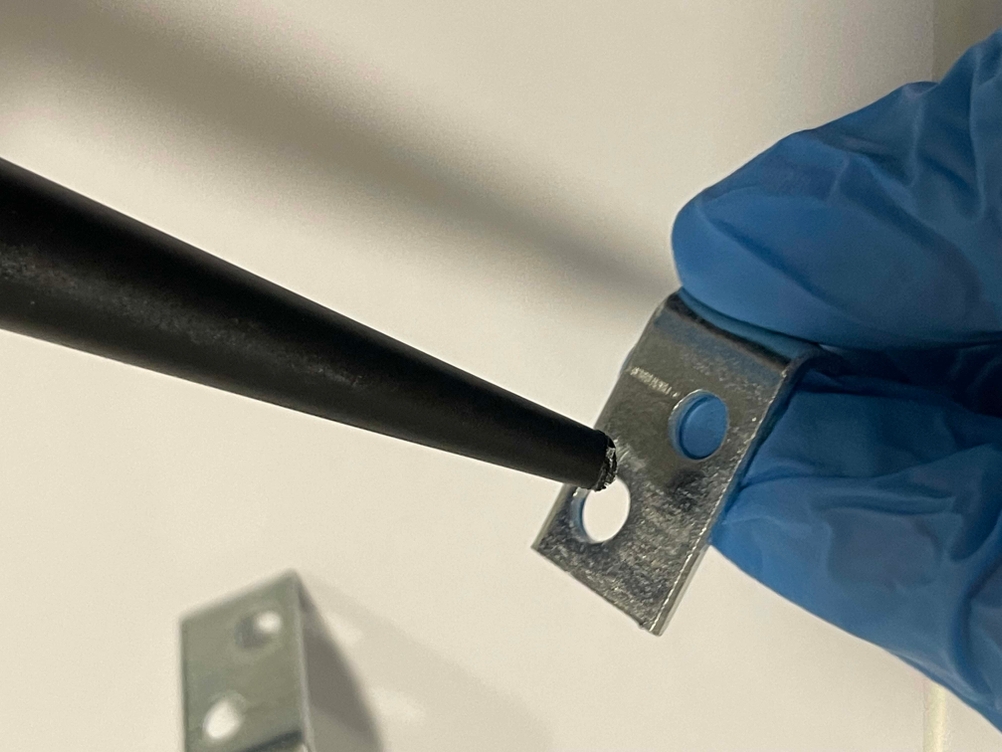 Metallkleber wird auf ein kleines Metallteil aufgetragen.