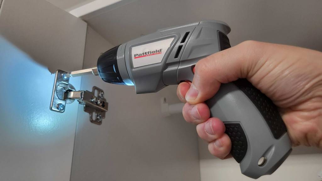 Eine Hand testet einen bürstenlosen Akkuschrauber inklusive LED-Leuchte beim Zusammenschrauben von Möbeln.