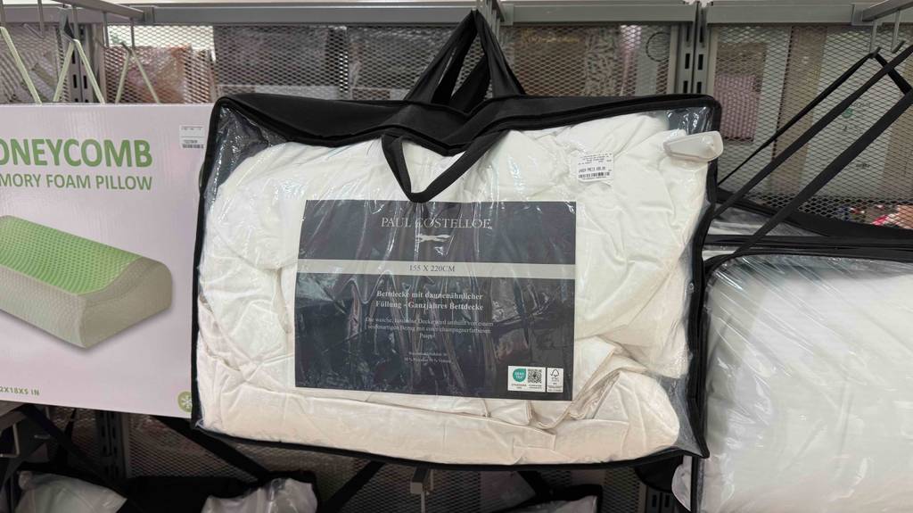 Bettdecke 155x200 im Test: Mehrere Packungen hängen zwischen anderen Schlafprodukten.