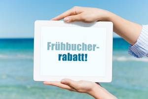 Test von Pauschalreisen: Zwei Hände halten ein Schild mit der Aufschrift