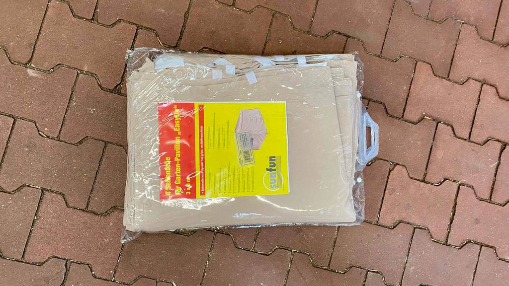 Ein getesteter Pavillon liegt verpackt auf dem Boden.