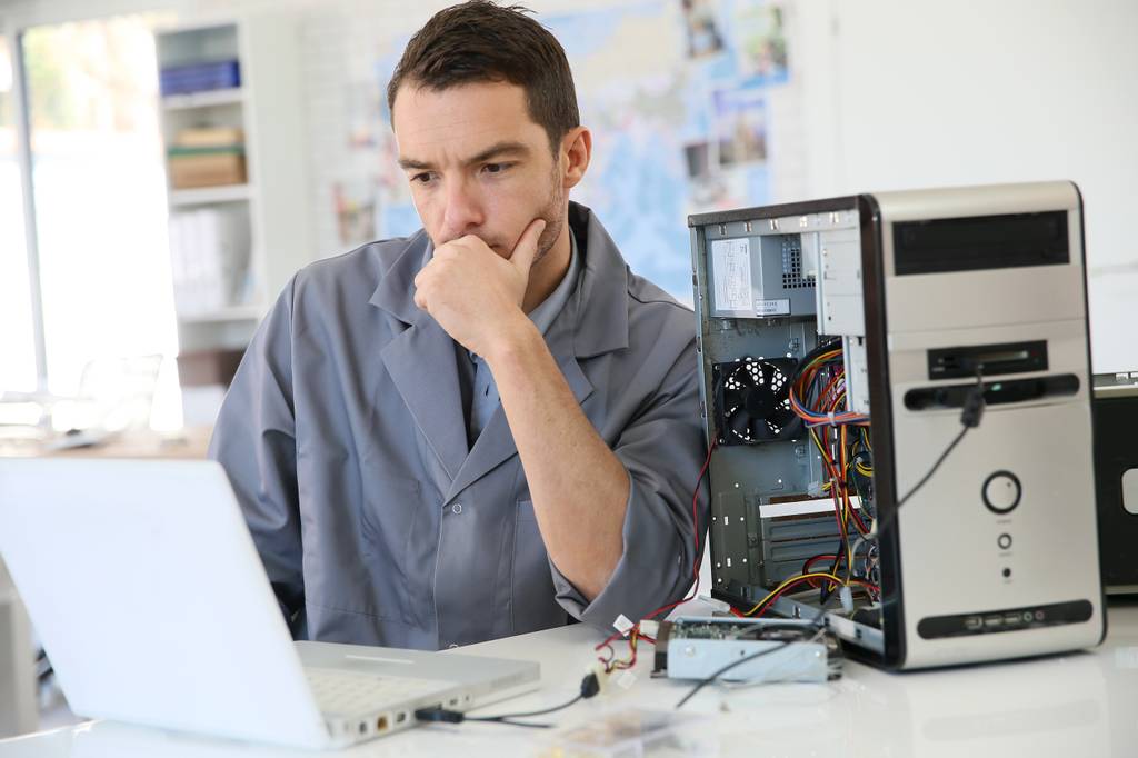 Ein Service-Mitarbeiter testet Hardware an einem PC.