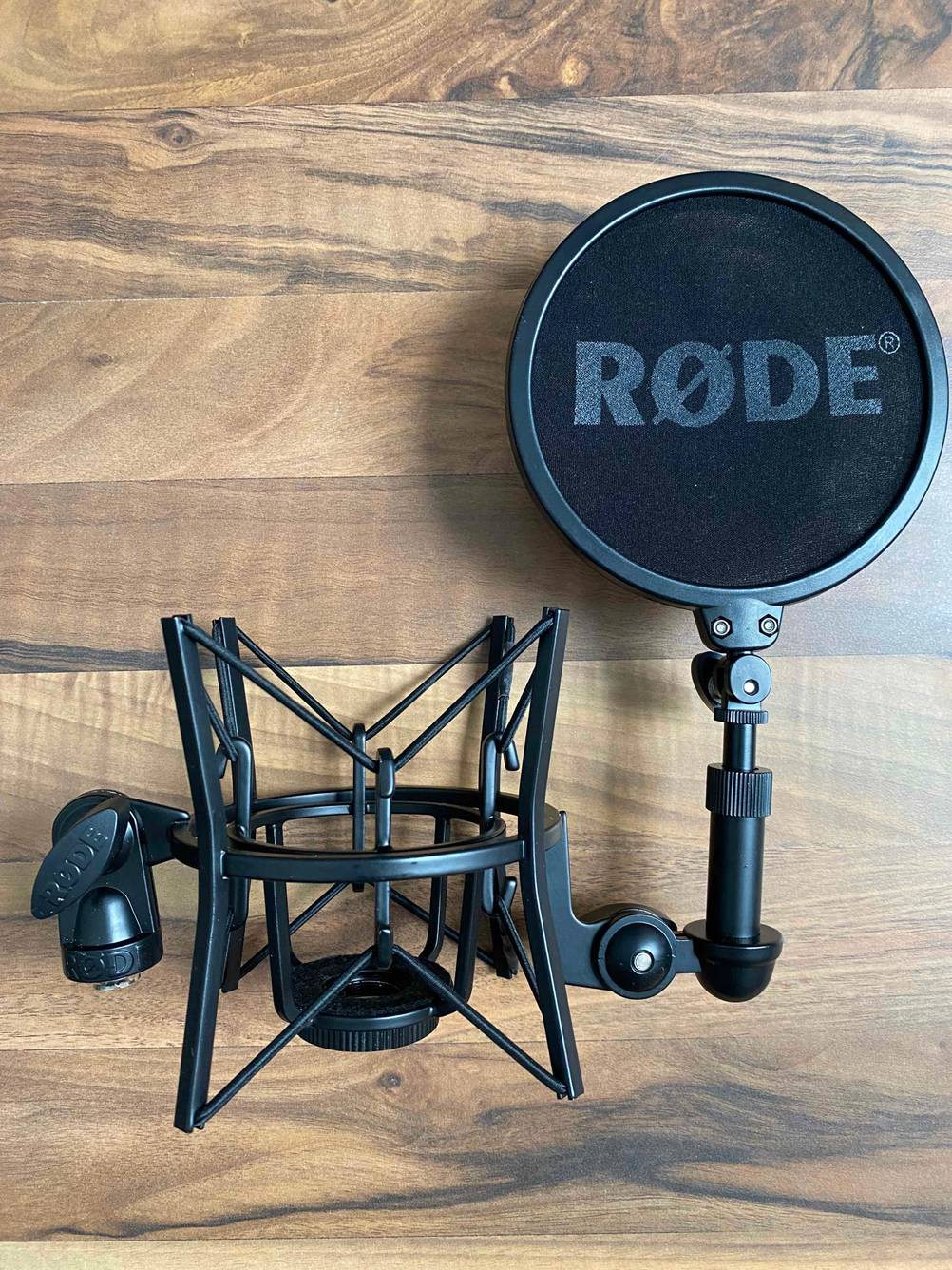 Im Test: Mikrofonspinne inklusive Popschutz eines PC-Mikrofons auf einer Holzfläche.