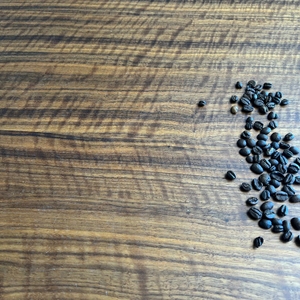 Zucker wurde aufgesaugt und ist entfernt, es sind auf dem Tisch nur noch Kaffeebohnen zu sehen.