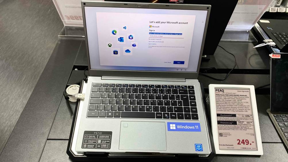 Im Test: Ein günstiger Laptop aufgeklappt in einer Verkaufsausstellung neben dem Preisschild.