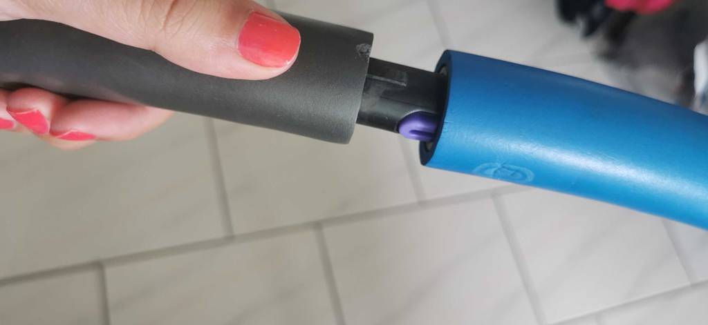 Hand, die zwei Teile eines Hula Hoop Reifens zusammenklickt