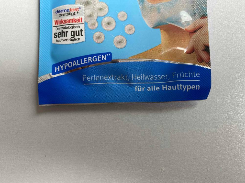 Detailaufnahme des Aufdrucks der Vorderseite einer getesteten Peel-off-Maske mit Informationen.