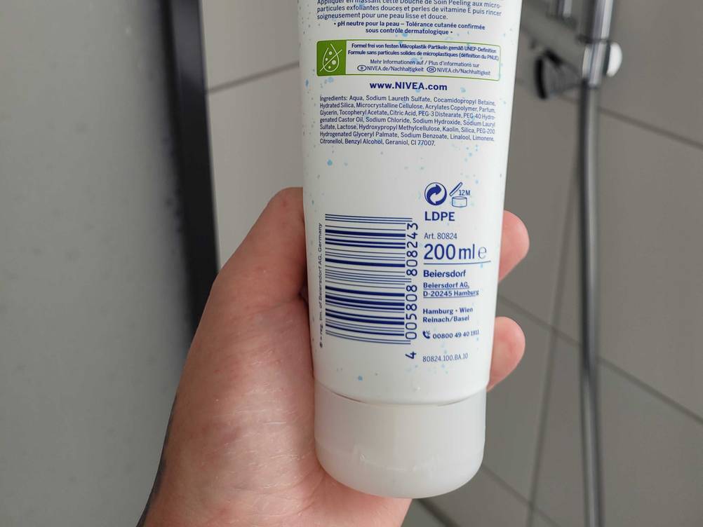 Peeling getestet: Nahaufnahme der Rückseite einer Verpackung mit Strichcode, von einer Hand gehalten.