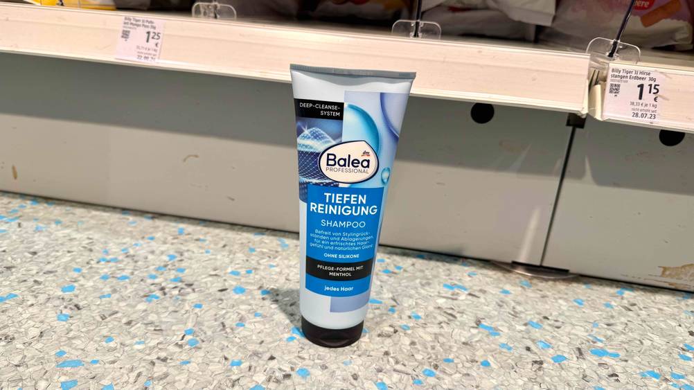 Peeling-Shampoo im Test: Eine Tube vor einem Regal auf dem Boden stehend.